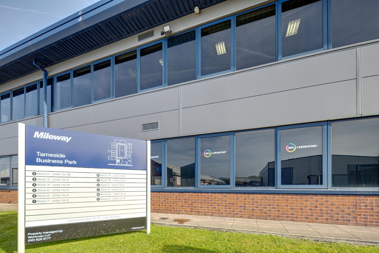A business park building with large windows and a sign in front listing units at Tameside Business Park under the Mileway property brand.