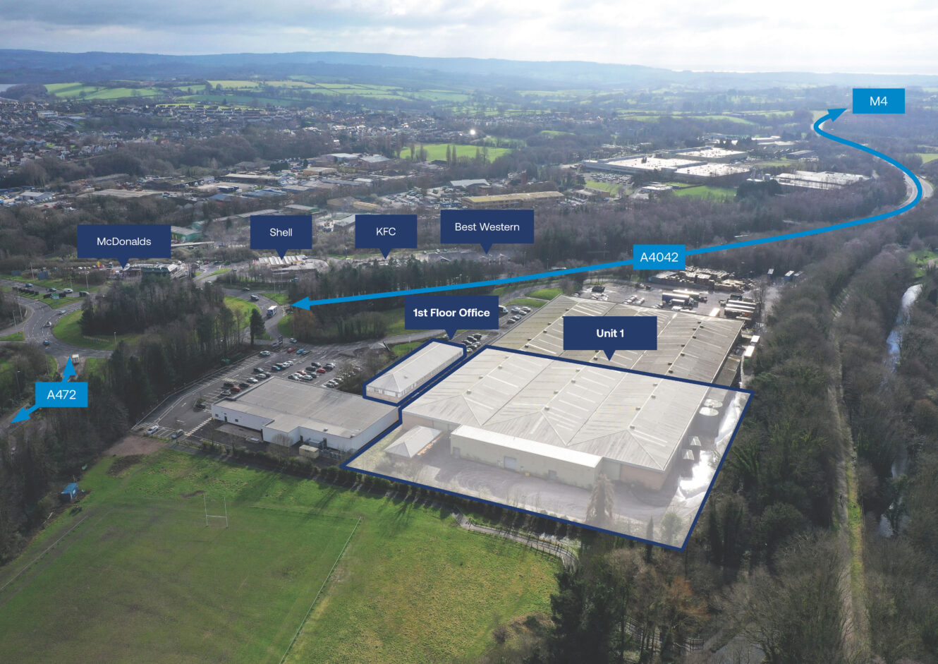 Aerial view of an industrial complex near highways, with labeled buildings, parking lots, and nearby businesses such as McDonalds, Shell, KFC, and Best Western.