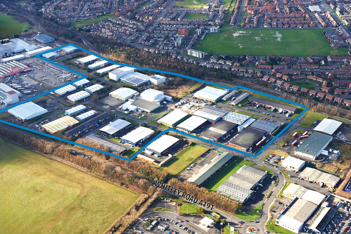 Aerial view of an industrial estate bordered in blue, with warehouses and buildings near residential neighborhoods and fields, adjacent to Whitley Road A191.