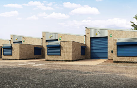 A row of modern industrial warehouse units with beige brick walls, blue roller doors, and numbered signs under a partly cloudy sky.
