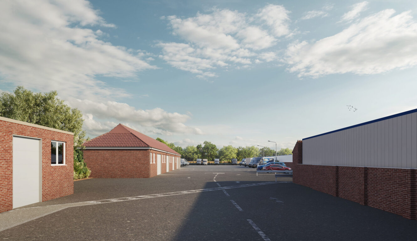 A paved car park with several parked cars, bordered by brick and metal buildings, under a partly cloudy sky with trees in the background.