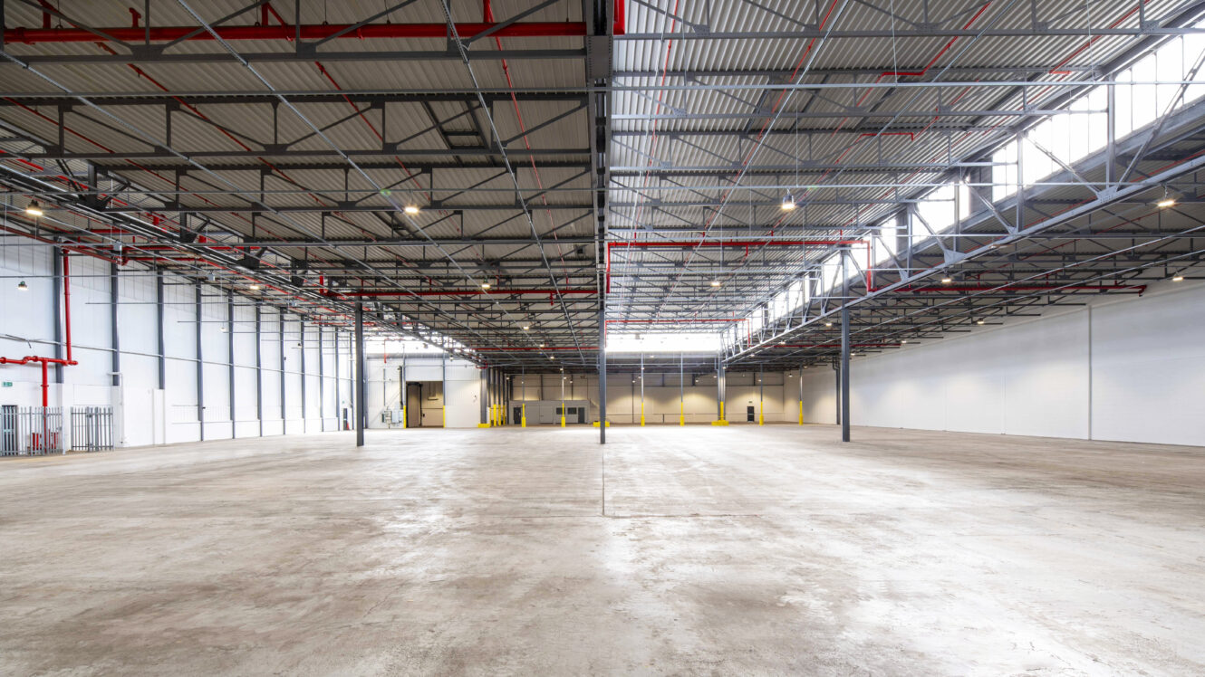 A large empty warehouse with red and yellow lines.