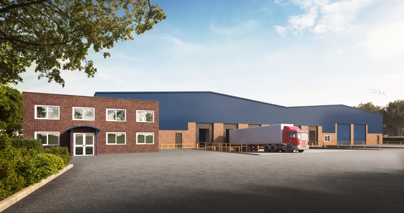 A large warehouse with blue cladding and brick frontage stands behind an office building; a red lorry is parked at one of the loading bays under a clear sky.