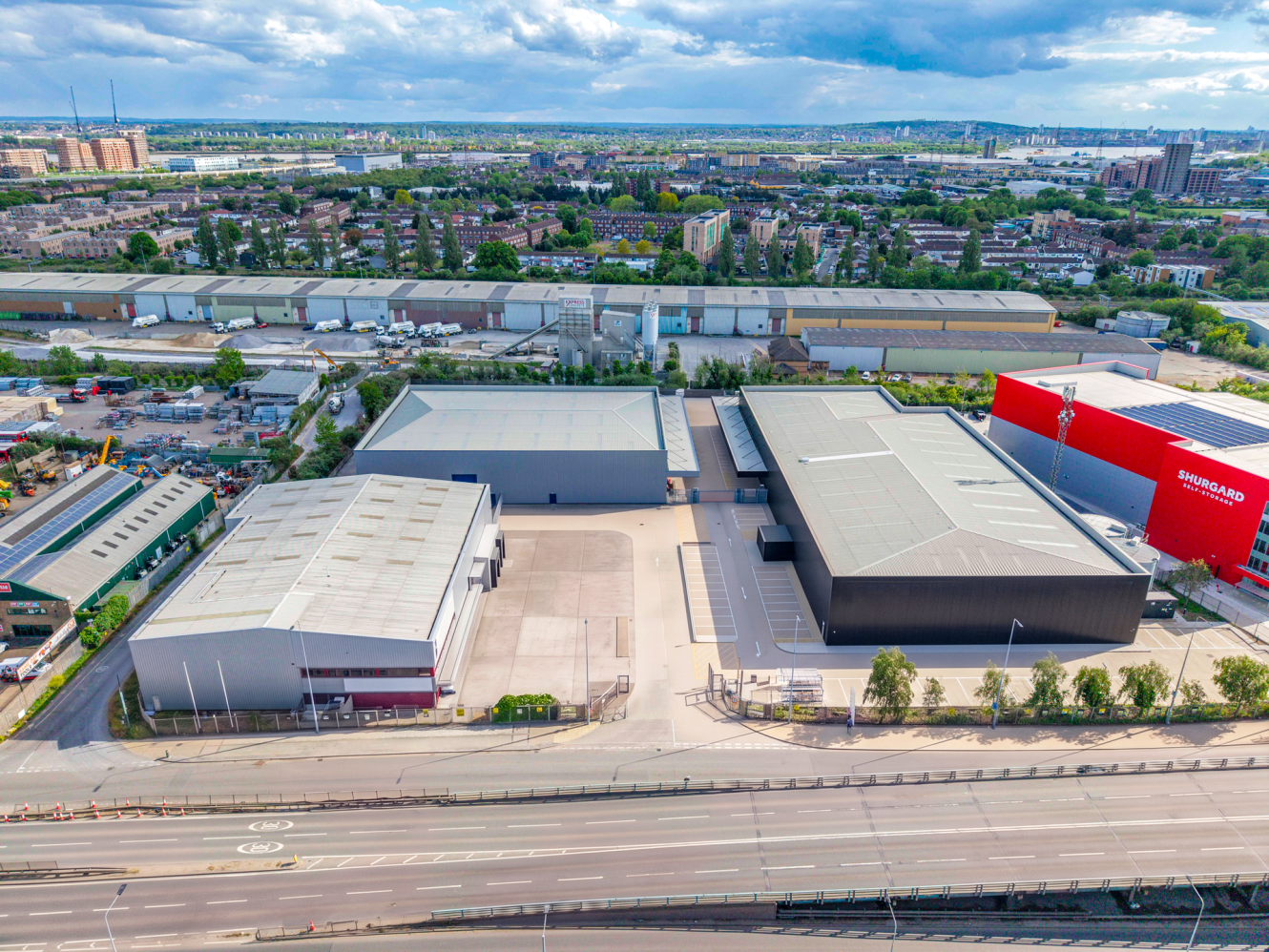 Aerial view of a large industrial estate with warehouses, a red building labelled SUNBURST, and adjacent roads surrounded by cityscape.