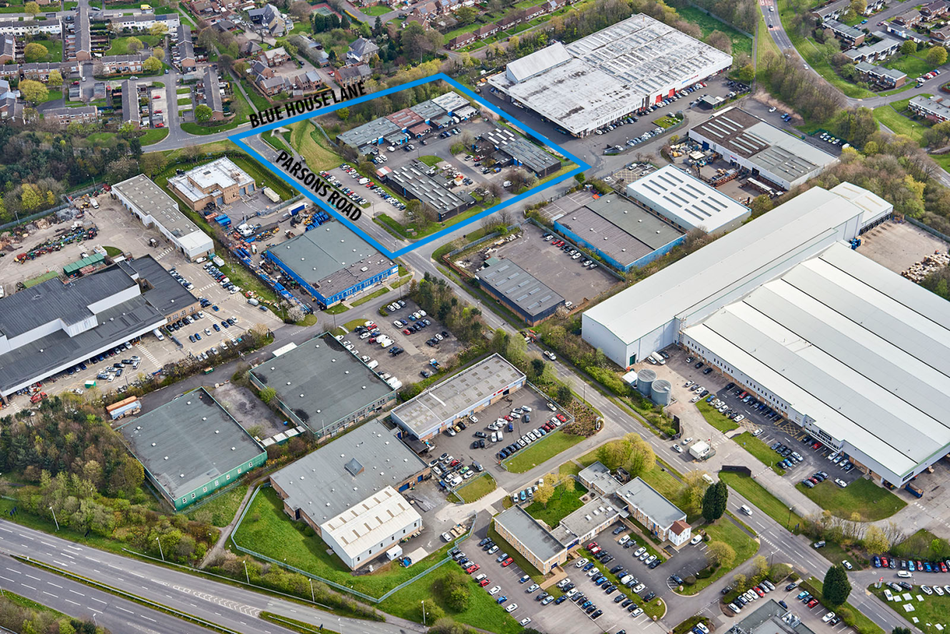 Aerial view of an industrial estate featuring several warehouses, office buildings, and car parks; Blue House Lane and Parsons Road are marked in blue.