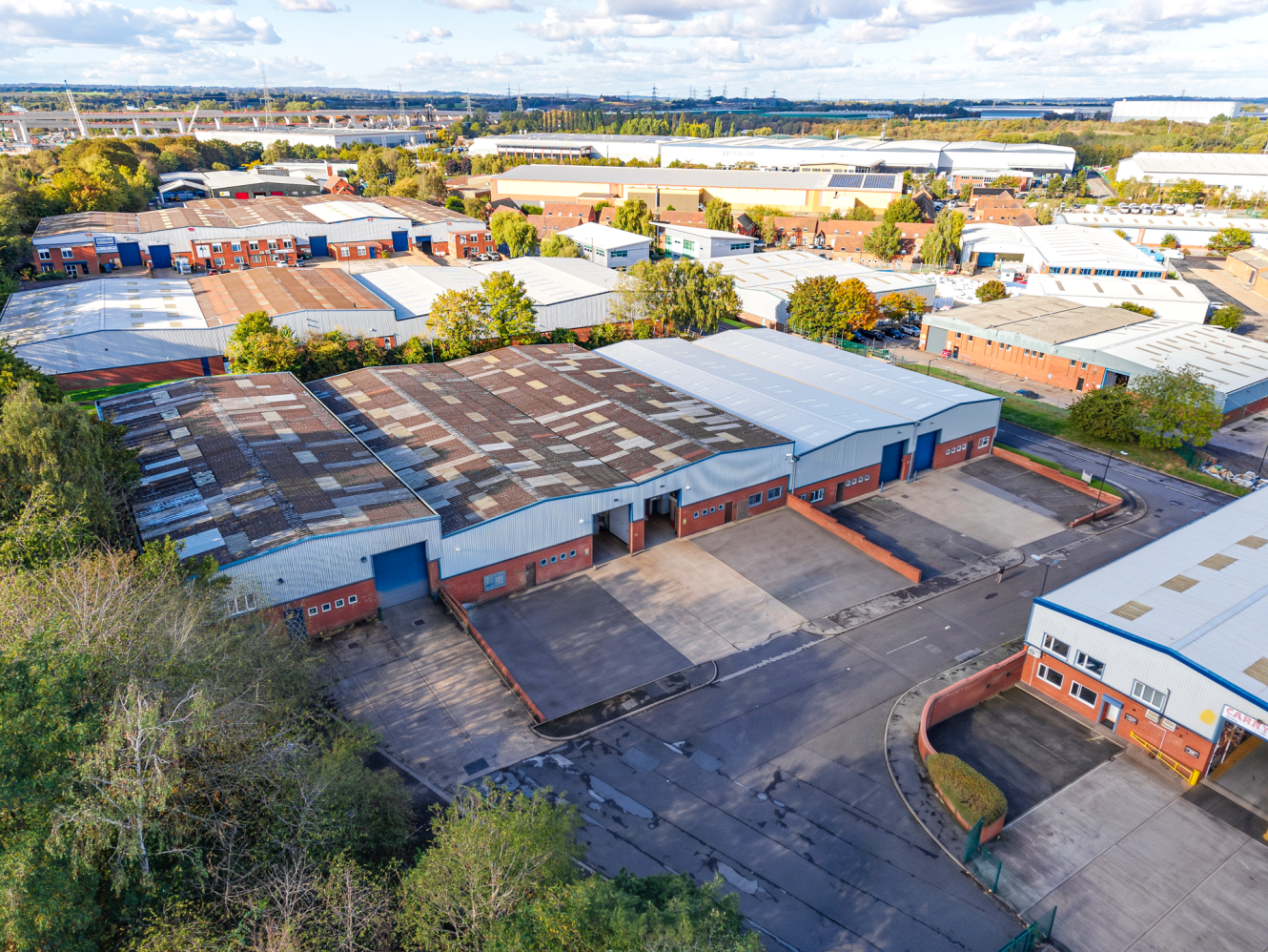 Aerial view of an industrial estate featuring multiple warehouses with loading bays and parking areas.