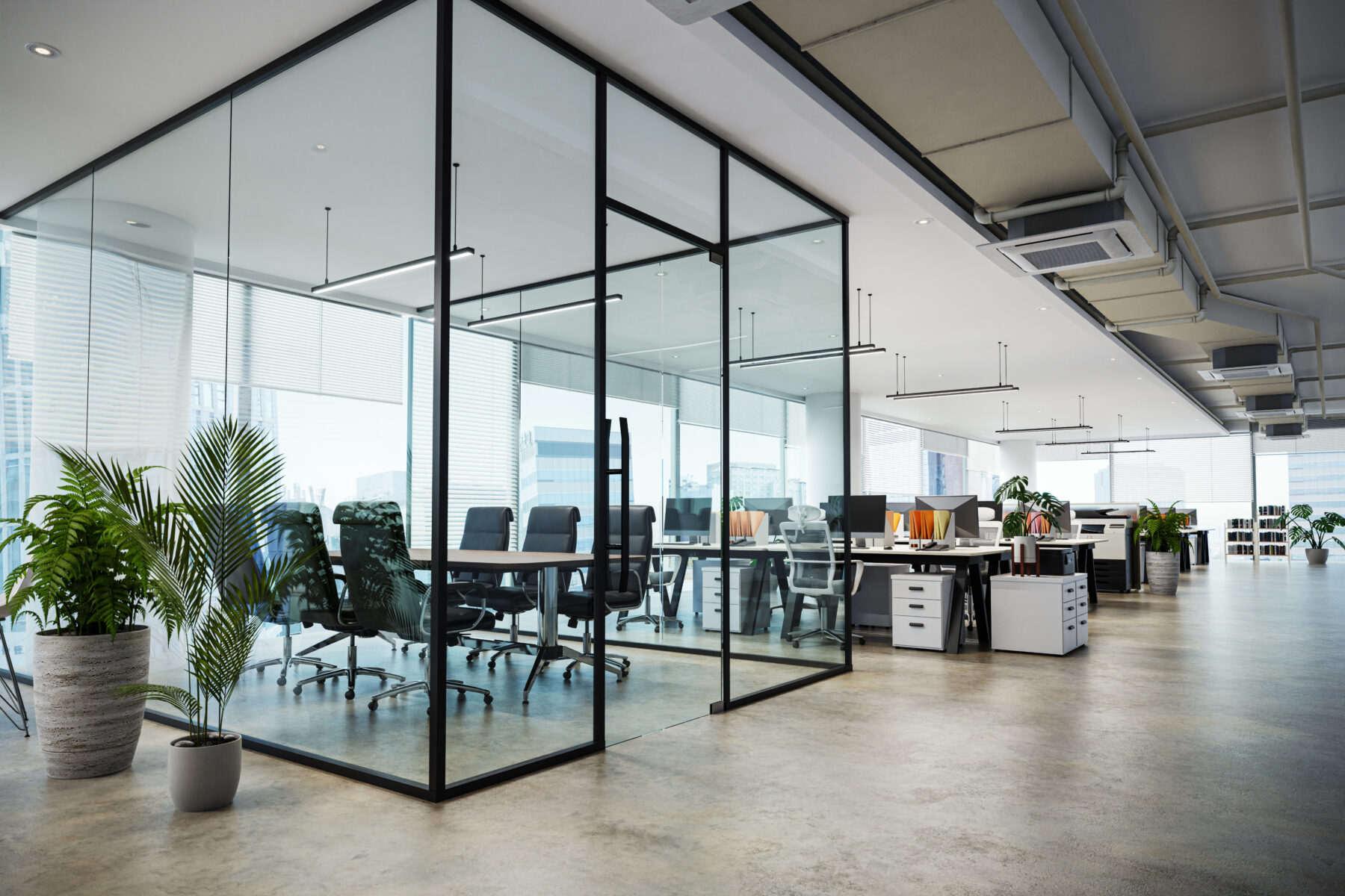 An open-plan office space featuring a glass-enclosed meeting room and rows of desks with computers.