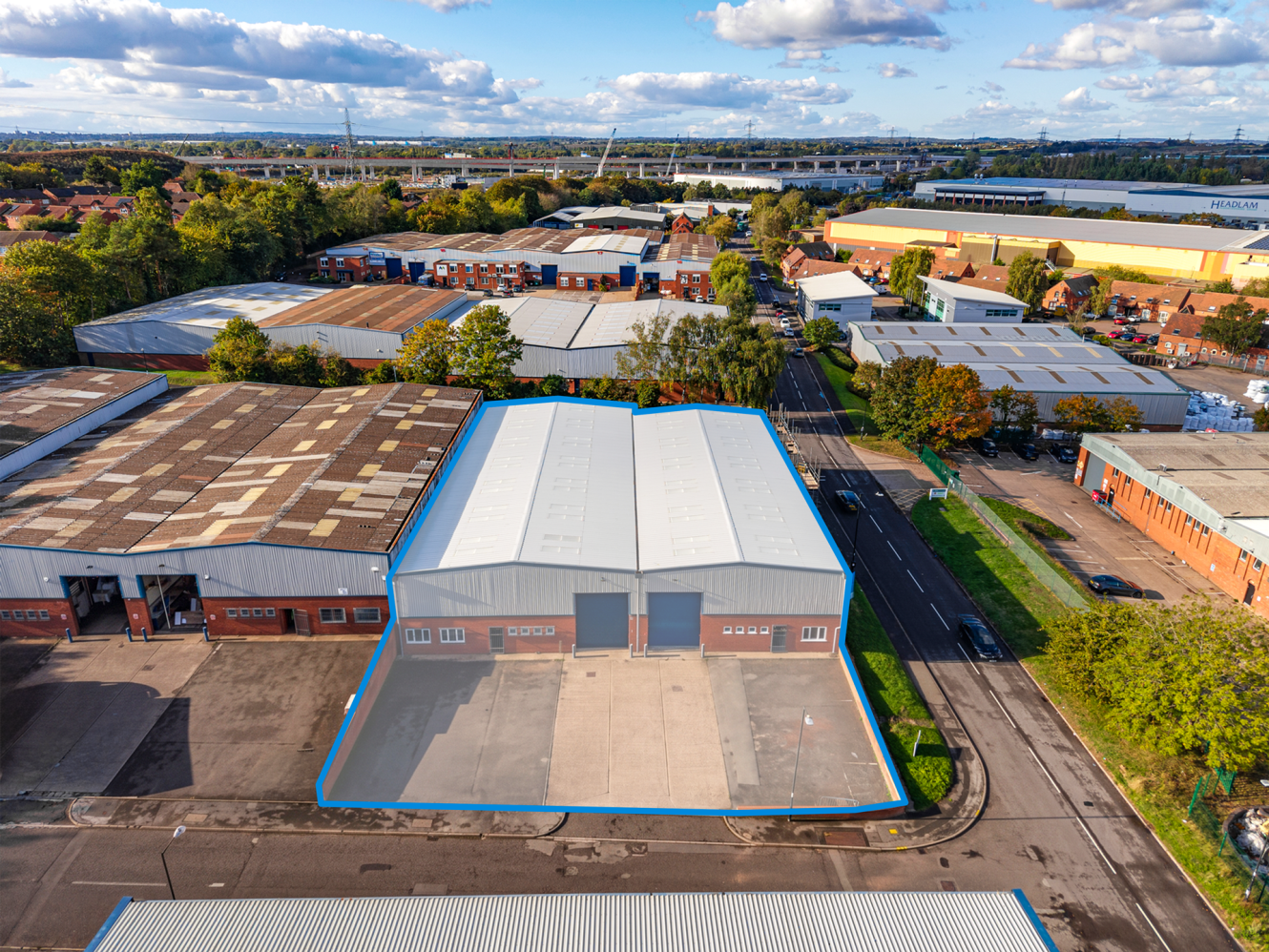 Aerial view of an industrial estate highlighting a detached warehouse with a large forecourt.
