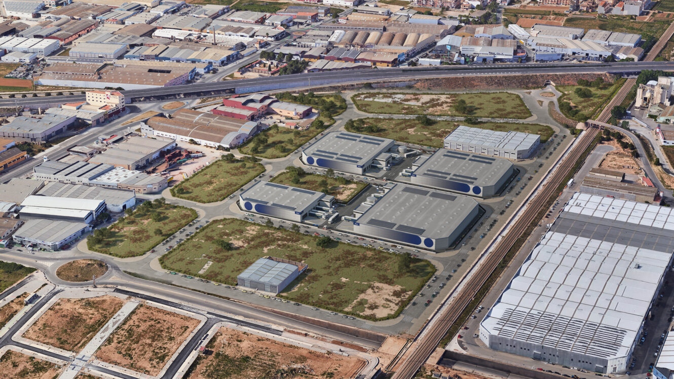 Vista aérea de un polígono industrial con almacenes, naves industriales, carreteras y parcelas sin urbanizar rodeadas de instalaciones industriales adicionales.