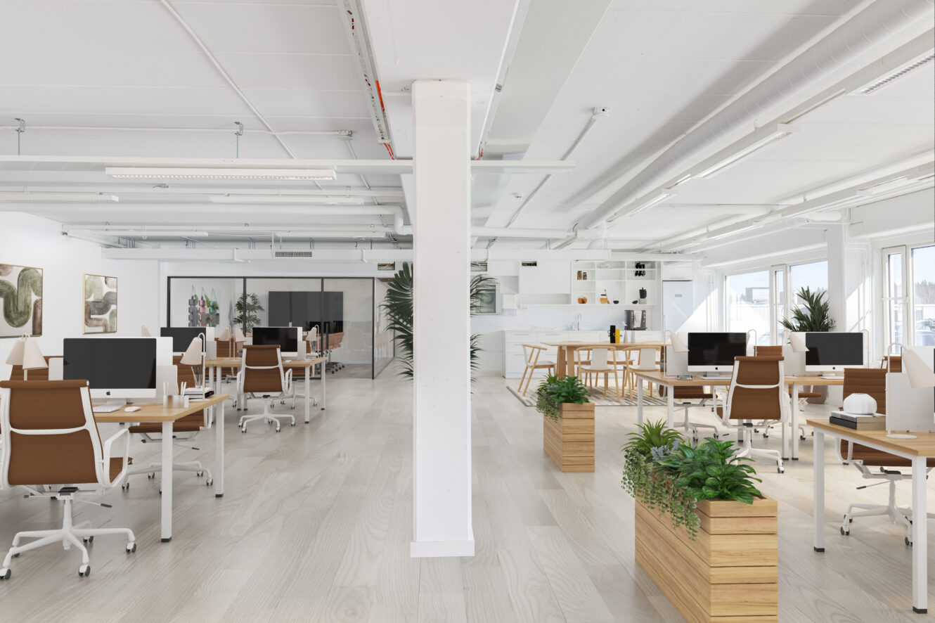 Moderni avotoimisto, jossa on puupöydät, ruskeat tuolit, tietokoneet, huonekasvit ja suuret ikkunat, jotka antavat luonnonvaloa. Etualalla on keskellä pylväs.