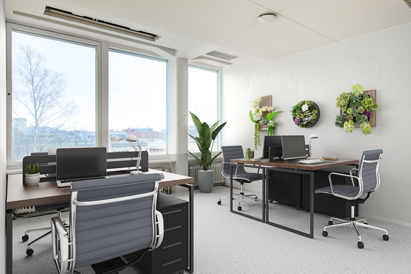 Moderni toimisto, jossa on neljä työpöytää, ergonomiset tuolit, kannettavat tietokoneet, suuret ikkunat, ruukkukasvit ja seinälle kiinnitetyt kasvikoristeet. Valoisa, siisti ja järjestetty työtila.