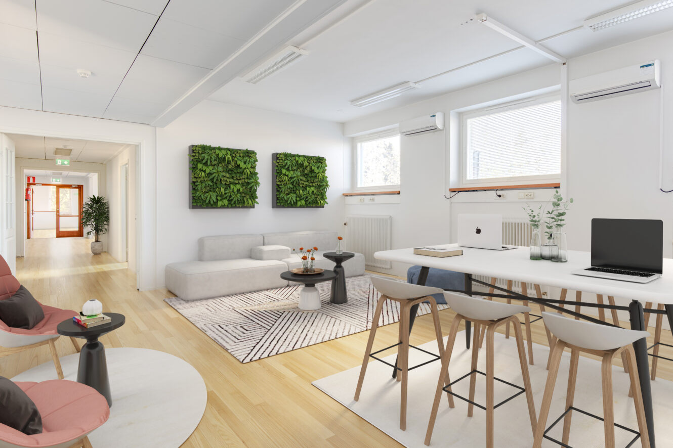 Moderni toimiston oleskelutila, jossa on valkoiset seinät, puulattiat, sohva, seinälle kiinnitetty kasvikoriste, korkea pöytä jakkaroilla, kannettavat tietokoneet ja suuret ikkunat, joista pääsee luonnonvaloa.