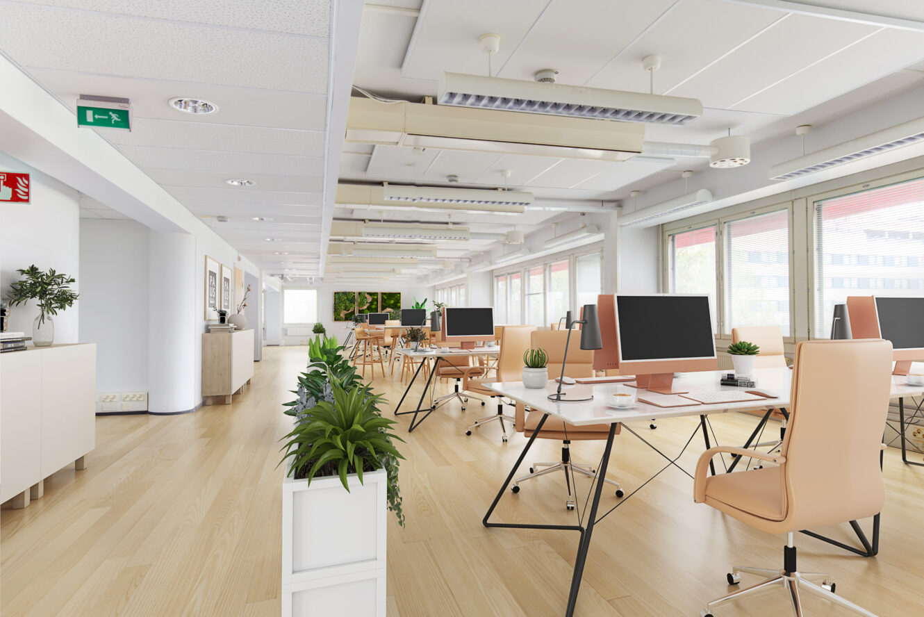 Moderni avotoimisto, jossa on puulattiat, vaaleat pöydät ja tuolit, pöytätietokoneet, suuret ikkunat ja useita huonekasveja.