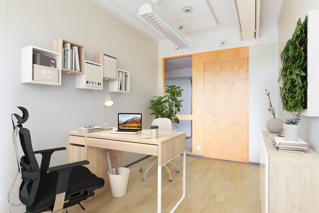 Moderni, minimalistinen toimisto, jossa on puinen työpöytä, musta tuoli, kannettava tietokone, ruukkukasveja, seinähyllyjä ja suljettu puuovi. Luonnonvalo kirkastaa tilaa.