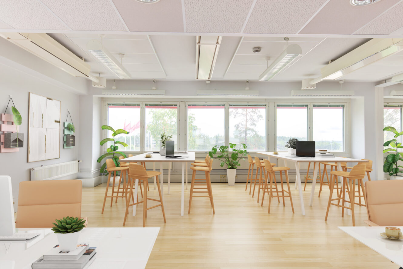 Moderni, valoisa toimistotila, jossa on suuret ikkunat, puulattiat, useita pöytiä ja tuoleja, tietokoneita, huonekasveja ja seinätaidetta.