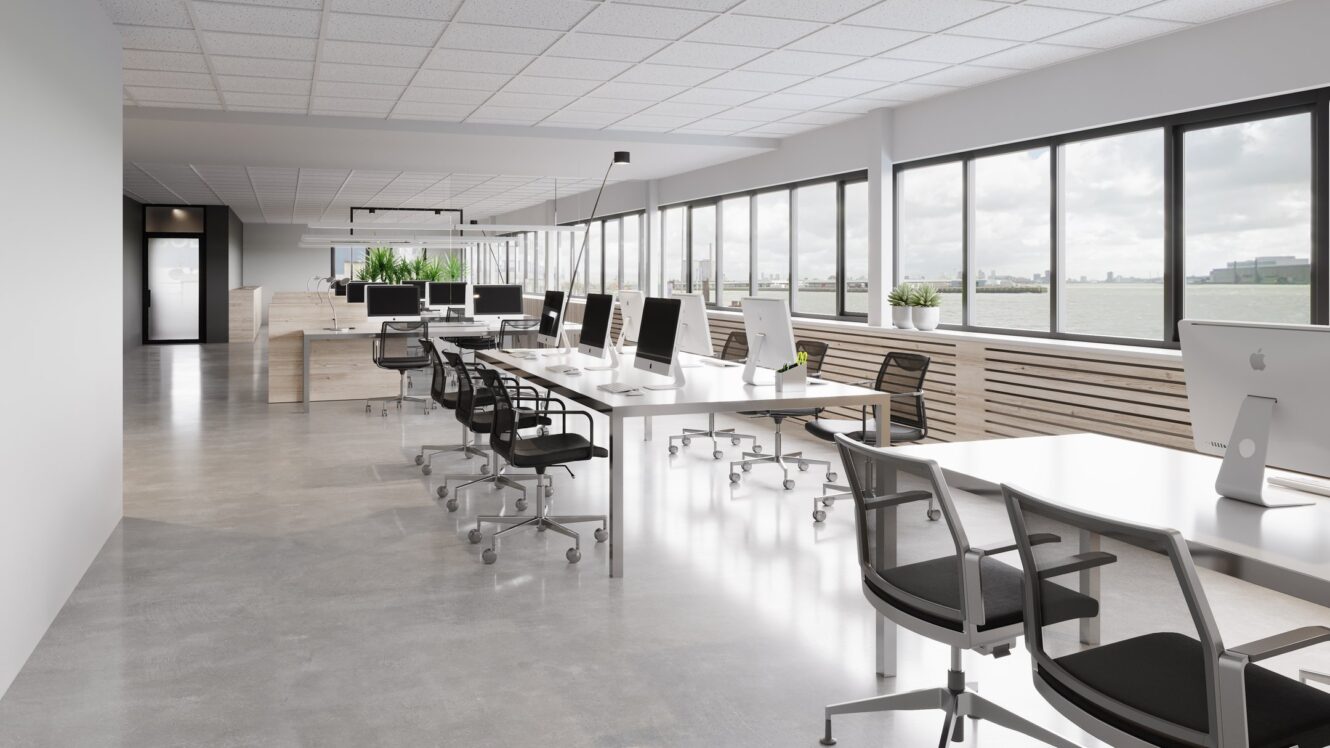 Modern open kantoor met rijen bureaus, computers, zwarte stoelen, grote ramen, kamerplanten en uitzicht op water en stadsgebouwen buiten.