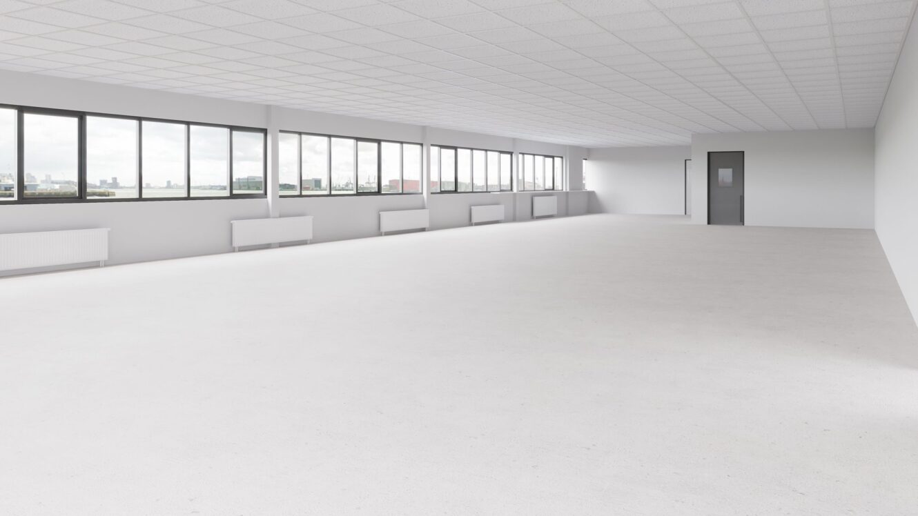 Lege, ongemeubileerde kantoorruimte met witte muren, grote ramen aan één kant, een rasterplafond en een enkele gesloten deur aan de andere kant van de muur.