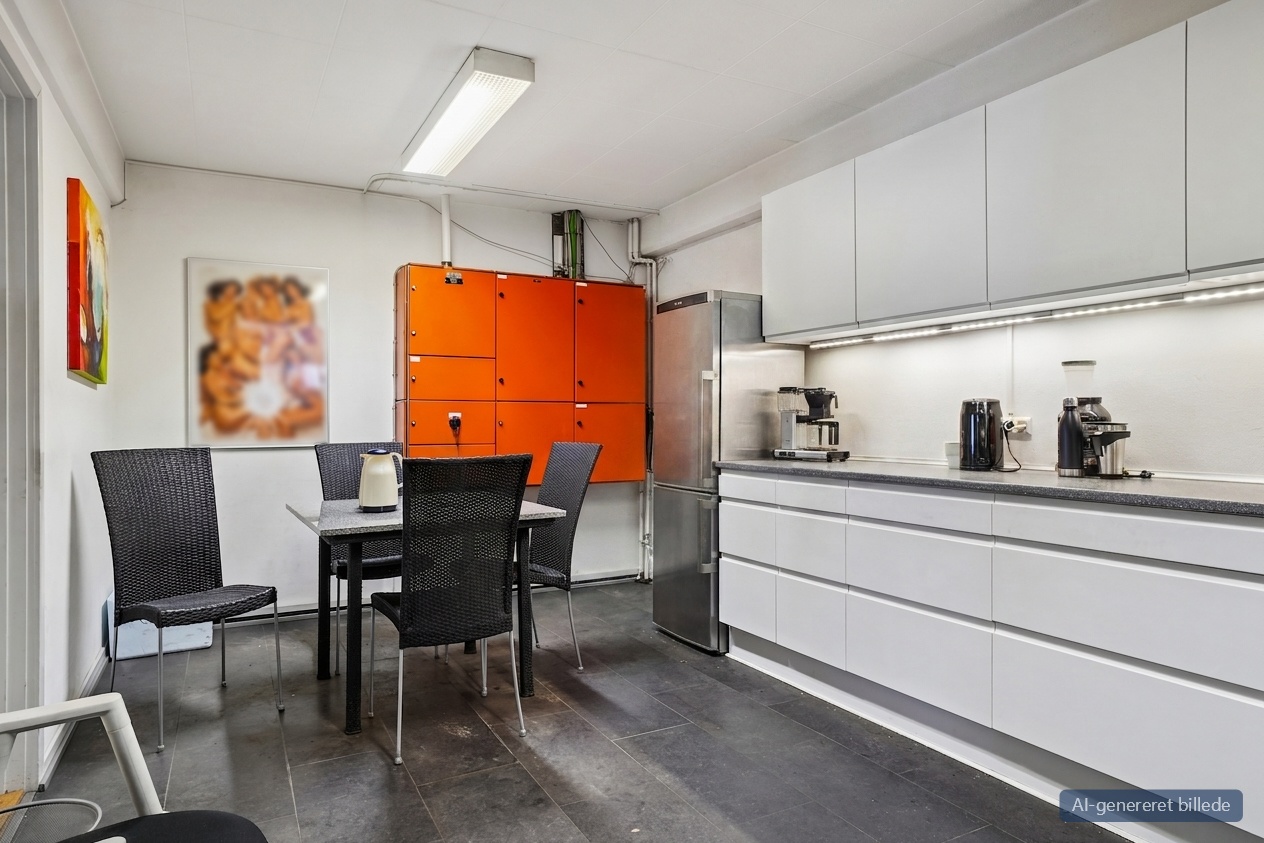 Moderne køkken med hvide skabe, køleskab i rustfrit stål, sort spisebord og stole, orange skabe og kaffemaskiner.