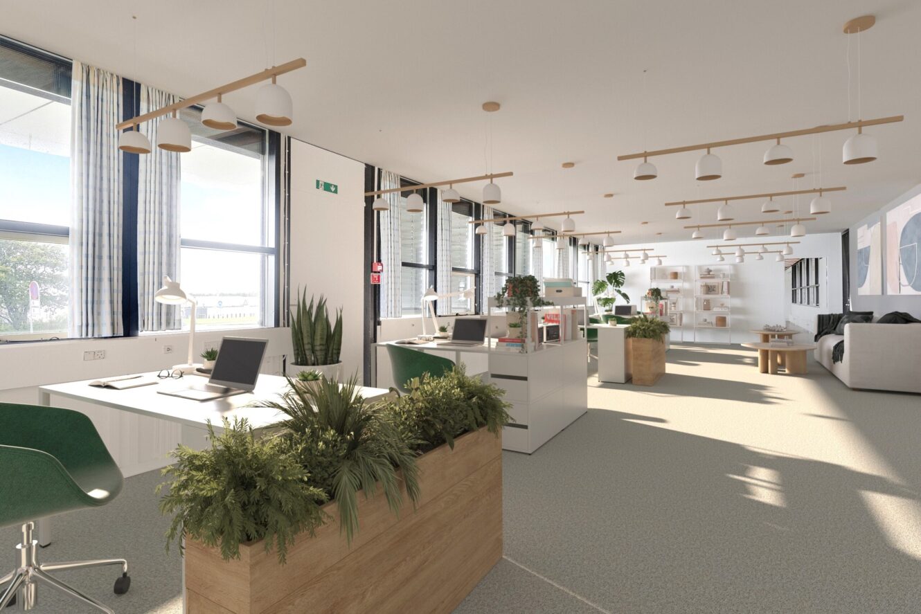 Moderne storrumskontor med store vinduer, naturligt lys, grønne planter, skriveborde med computere og et siddeområde i baggrunden.