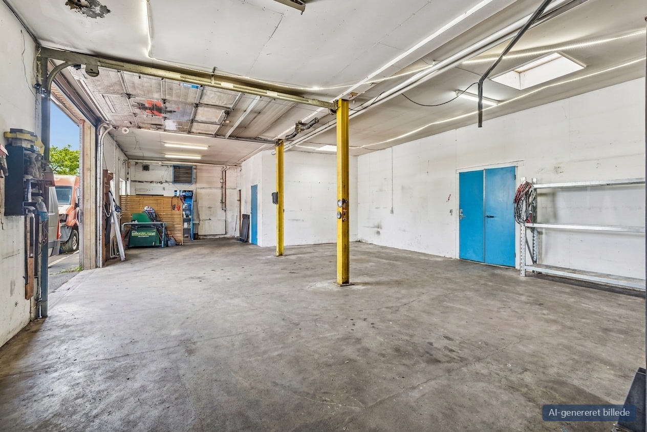 Rummelig industrigarage med betongulv, hvide vægge, gule søjler, blå dobbeltdøre, åben garageport, hylder og værktøj.