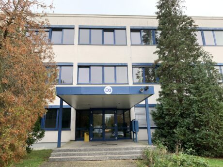 Der Eingang zu einem mehrstöckigen Bürogebäude, über dem die Aufschrift D3 angebracht ist.