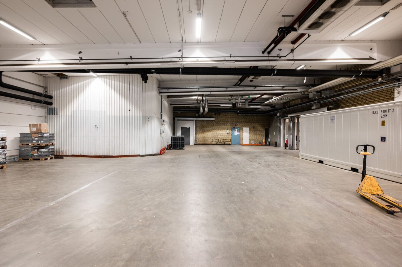 Ett stort rum med vita väggar och en tegelvägg.