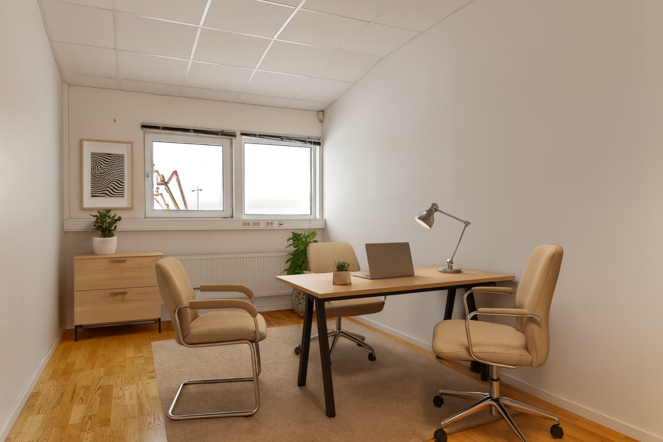 Minimalistiskt kontor med två beige stolar, ett skrivbord i trä med en bärbar dator och lampa, ett litet skåp, två krukväxter och ett fönster som visar byggutrustning utanför.