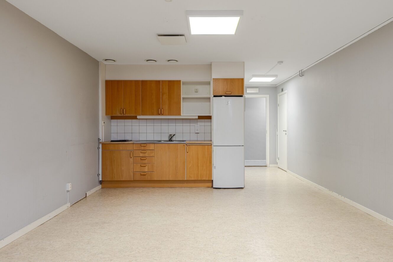 Ett kök med ett vitt kylskåp och vita skåp.