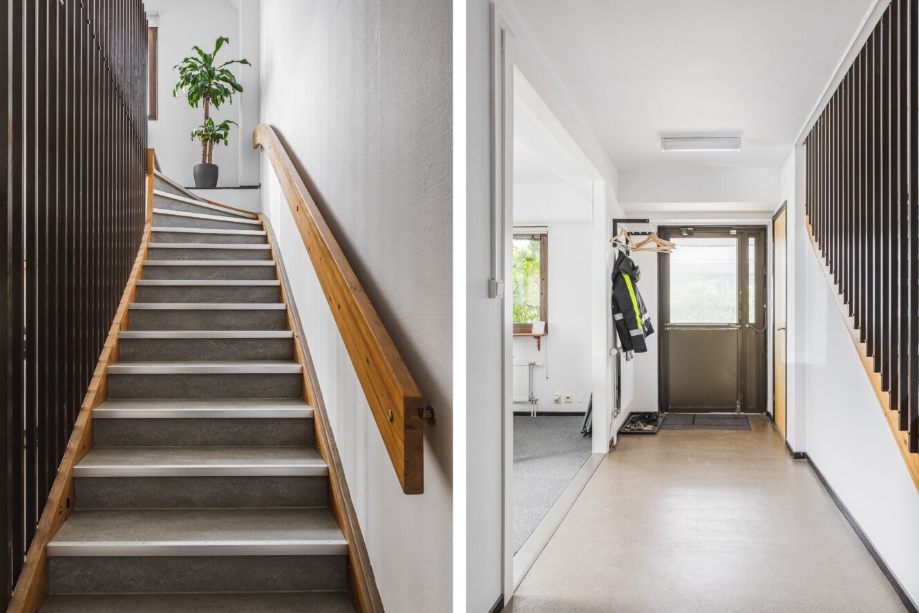 Delad vy av en inomhustrappa med ledstång av trä och en hall med klädkrokar, en dörr och en krukväxt.