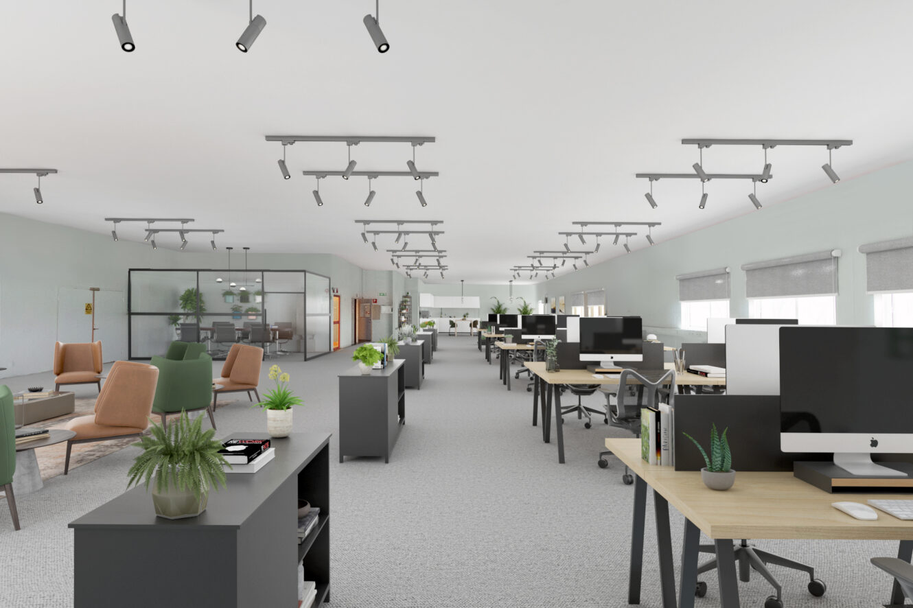 Modernt kontor i öppen planlösning med skrivbordsrader, datorer, kontorsstolar, krukväxter och loungemöbler, med stora fönster och neutral inredning.