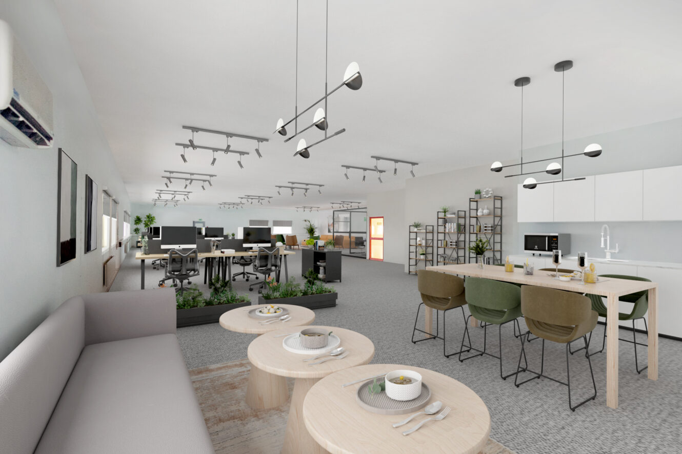 Modernt kontor i öppen planlösning med arbetsstationer, en lounge med bord och soffa samt ett kök med matbord och stolar under taklampor.