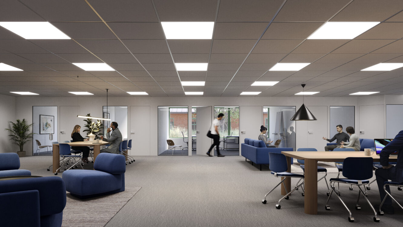 Modernt öppet kontorslandskap med flera personer som arbetar och samtalar vid bord; stark belysning, blå möbler och glasdörrar i bakgrunden.