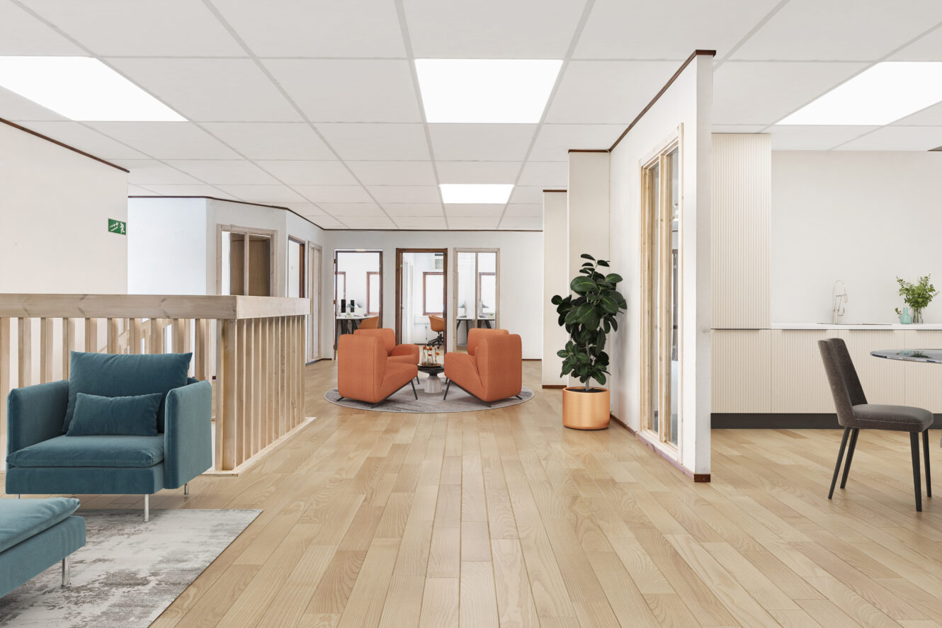 Modernt kontorsrum med ljust trägolv, blå och orange fåtöljer, glasväggar, en krukväxt och ett litet kök i bakgrunden.